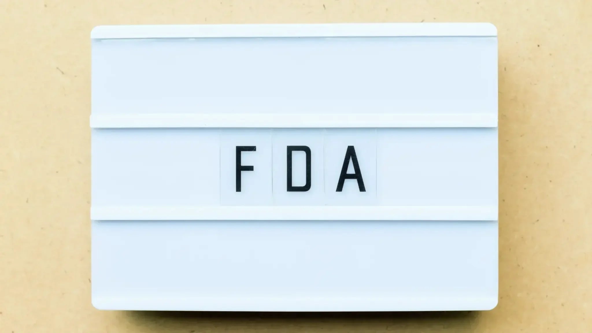 Lightbox sign displaying the letters ‘FDA’ in black on a white background, referencing the question of whether NMN is banned by the FDA.