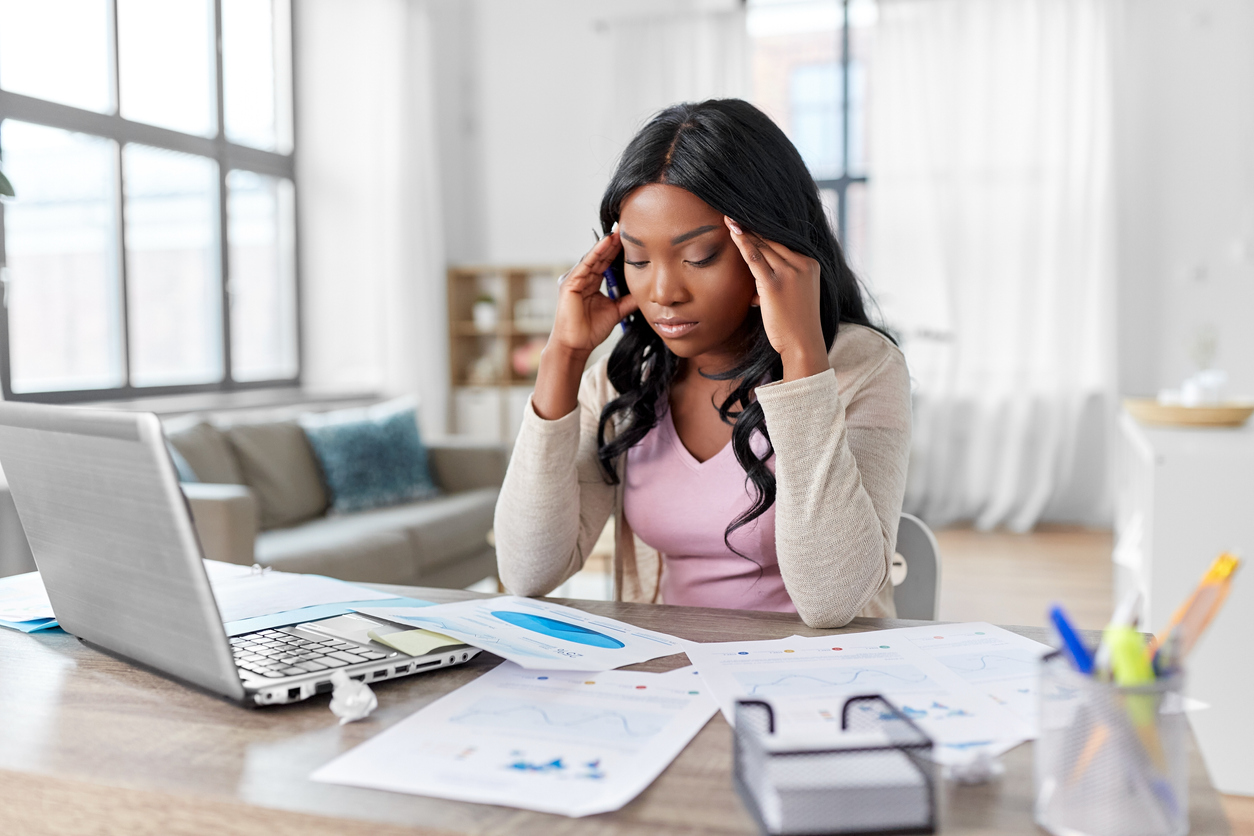 Stressed woman with papers working at home office