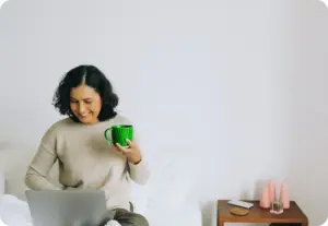 woman working on the laptop while drinking tea