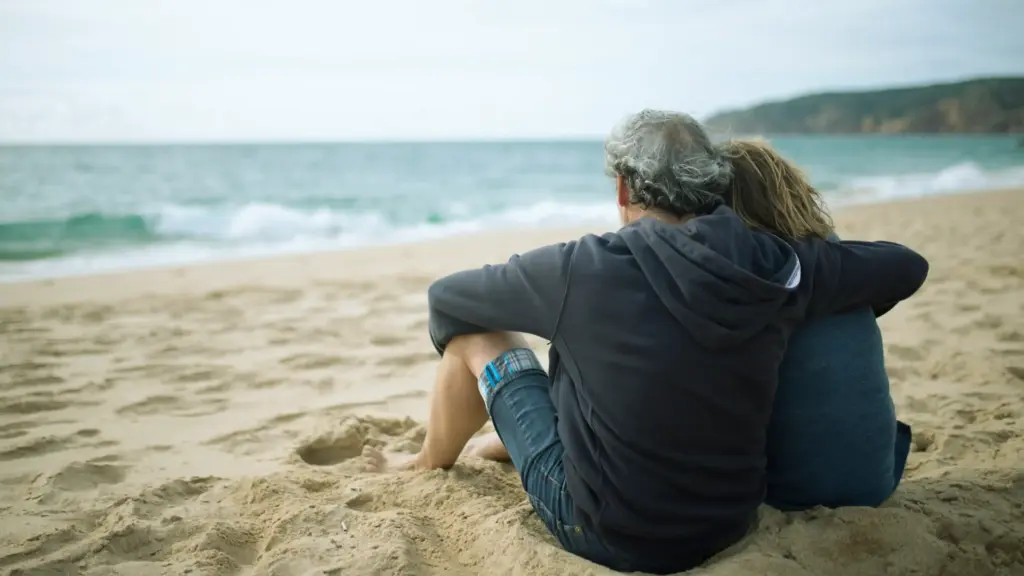 middle aged couple sitting by the sea