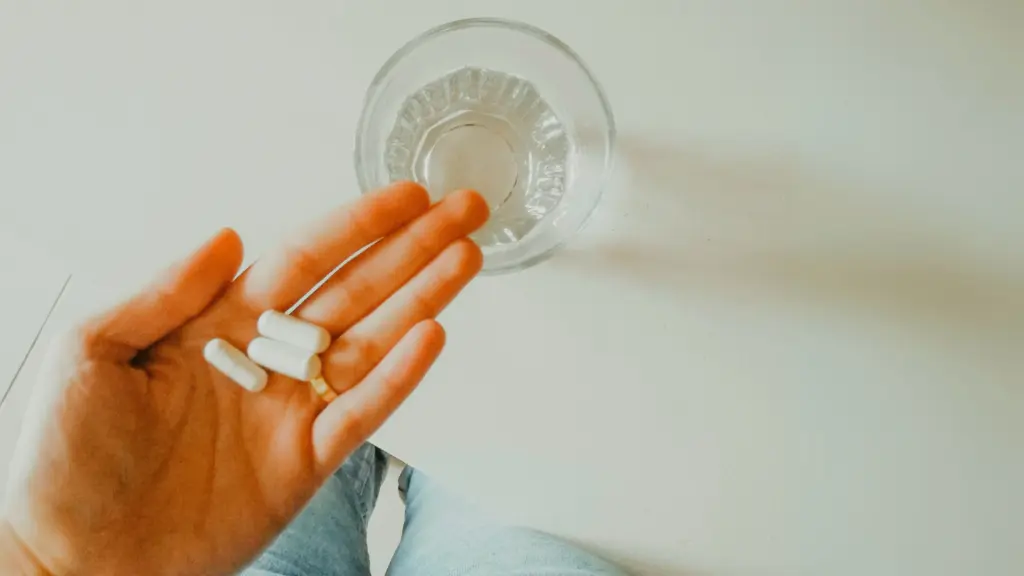 woman holding a couple of supplements in hand