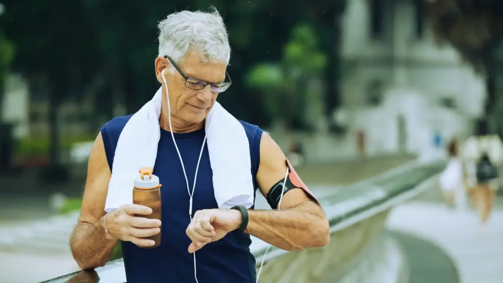 A man running and checking his watch, focused on tracking his performance