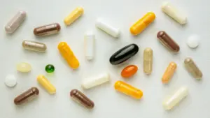 various supplement capsules in different shapes, sizes, and colors arranged on a white surface